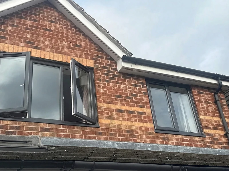 Anthracite grey casement windows installed on a brick home — Stylo Glazing