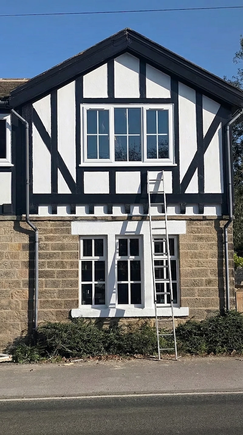 White uPVC windows on a Tudor-style Yorkshire stone property — heritage glazing